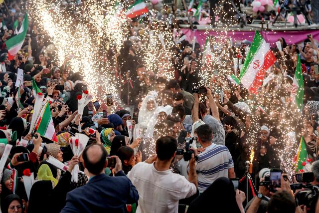 Sparks fly as bride and groom couples arrive for a public mass wedding ceremony at Imam Hossein Square in Tehran on May 18, 2026. Iran said on May 18 that it had responded to a new US proposal aimed at ending the war, adding that diplomatic exchanges continue despite Iranian media reports describing Washington's demands as excessive. Washington and Tehran have been swapping proposals in an effort to end the conflict which the US and Israel launched on February 28, but they have held only a single round of talks despite a fragile ceasefire. (Photo by AFP) / 