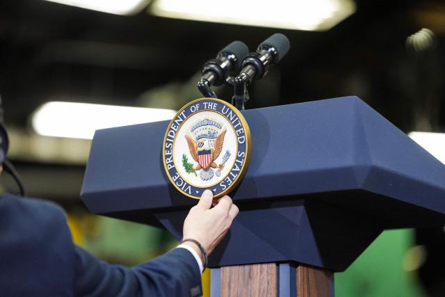 A staff member fixes the seal of the Vice President on a podium during an event with US Vice President JD Vance at Milbank Manufacturing Company in Kansas City, Missouri, on May 18, 2026. (Photo by Eric Lee / POOL / AFP)