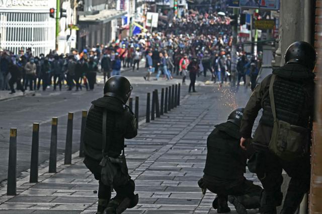 Riot police fire tear gas to demonstrators during a protest demanding the resignation of Bolivian President Rodrigo Paz, in La Paz, on May 18, 2026. Bolivians have taken to the streets for the past two weeks, blocking roads into La Paz and disrupting deliveries of food, medicine and other goods to the seat of government, while demanding higher wages, economic relief and the resignation of centre-right President Rodrigo Paz amid a severe economic crisis. (Photo by AIZAR RALDES / AFP)