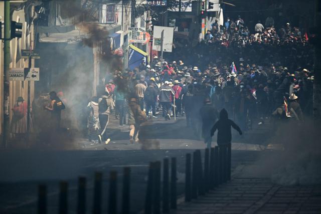 Protesters run to escape tear gas during clashes with riot police in a protest demanding the resignation of Bolivian President Rodrigo Paz, in La Paz, on May 18, 2026. Bolivians have taken to the streets for the past two weeks, blocking roads into La Paz and disrupting deliveries of food, medicine and other goods to the seat of government, while demanding higher wages, economic relief and the resignation of centre-right President Rodrigo Paz amid a severe economic crisis. (Photo by AIZAR RALDES / AFP)