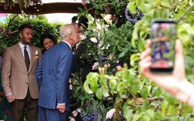 Former England footballer David Beckham (L) and designer Frances Tophill (2L) react as Britain's King Charles III smells a Sir David Beckham Rose, by David Austin Roses, at the 2026 RHS Chelsea Flower Show in London on May 18, 2026. (Photo by Adrian DENNIS / POOL / AFP)