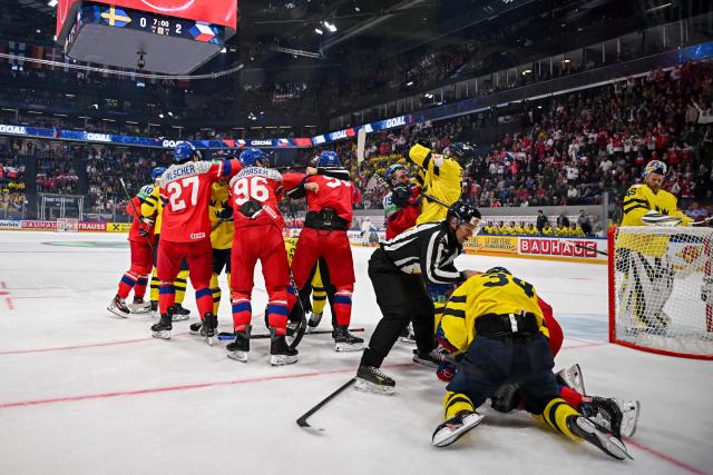 Players fight for the puck during the Group B ice hockey match between Sweden and Czech Republic at the IIHF Ice Hockey Men's World Championship at BFC Arena in Fribourg on May 18, 2026. (Photo by Fabrice COFFRINI / AFP)