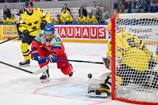 Czech Republic's forward #19 Jakub Flek (C) scores his team's third goal against Sweden's goalkeeper #45 Magnus Hellberg (R) during the groupe B match between Sweden and Czech Republic at the IIHF Ice Hockey Men's World Championship at BFC Arena, in Fribourg, Switzerland, on May 18, 2026. (Photo by Fabrice COFFRINI / AFP)