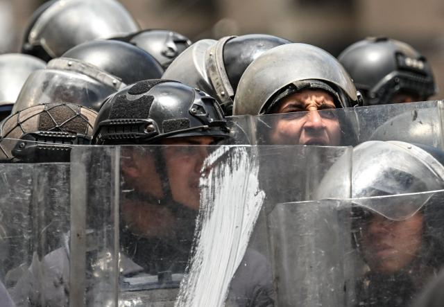 Members of Bolivarian National Police (PNB) officers are seen during a protest following the death of Carmen Navas, the mother of late political prisoner Victor Quero Navas, in Caracas, on May 18, 2026. The mother of Venezuelan political prisoner Victor Hugo Quero Navas died on May 17, 2026 at age 81, just days after confirming the death of her son in state custody, her relatives told AFP. (Photo by Juan BARRETO / AFP)