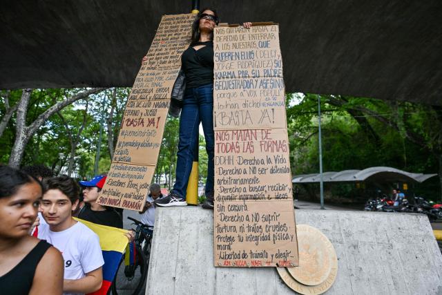 A woman protests following the death of Carmen Navas, the mother of late political prisoner Victor Quero Navas, in Caracas, on May 18, 2026. The mother of Venezuelan political prisoner Victor Hugo Quero Navas died on May 17, 2026 at age 81, just days after confirming the death of her son in state custody, her relatives told AFP. (Photo by Juan BARRETO / AFP)
