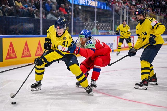 Sweden's forward #41 Ivar Stenberg (L) and Czech Republic's defender #26 Jiri Tichacek (C) fight for the puck during the Group B ice hockey match between Sweden and Czech Republic at the IIHF Ice Hockey Men's World Championship at BFC Arena in Fribourg on May 18, 2026. (Photo by Fabrice COFFRINI / AFP)