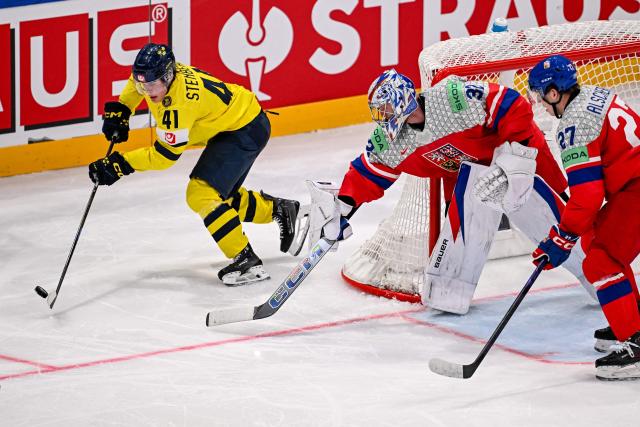 Sweden's forward #41 Ivar Stenberg (L) controls the puck next to Czech Republic's goalkeeper #32 Josef Korenar (C) during the Group B ice hockey match between Sweden and Czech Republic at the IIHF Ice Hockey Men's World Championship at BFC Arena in Fribourg on May 18, 2026. (Photo by Fabrice COFFRINI / AFP)