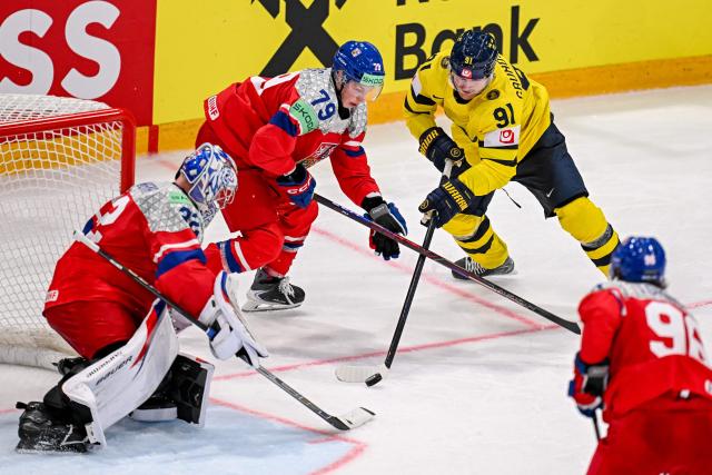Sweden's forward #91 Carl Grundstrom (R), Czech Republic's defender #79 Tomas Galvas (C) and Czech Republic's goalkeeper #32 Josef Korenar (L) fight for the puck during the Group B ice hockey match between Sweden and Czech Republic at the IIHF Ice Hockey Men's World Championship at BFC Arena in Fribourg on May 18, 2026. (Photo by Fabrice COFFRINI / AFP)