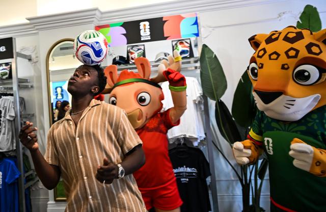A customer plays with a football while shopping during the opening day of the official 2026 FIFA World Cup merchandising store in Miami Beach, Florida, on May 18, 2026. (Photo by CHANDAN KHANNA / AFP)