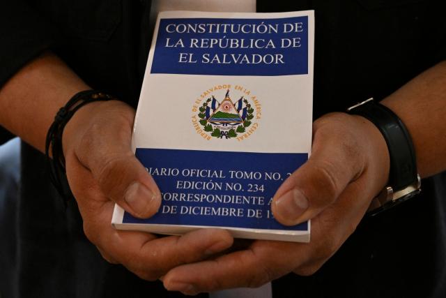 The director of research of the NGO Cristosal, Rene Valiente, holds a copy of El Salvador's constitution during a religious ceremony in honour of Salvadoran lawyer Ruth Lopez at the chapel of Rafael Landivar University in Guatemala City on May 18, 2026. The NGO Cristosal demanded proof regarding the health of Salvadoran lawyer Ruth Lopez, who was arrested a year ago after reporting alleged corruption cases in Nayib Bukele's government and who is being denied family visits. (Photo by JOHAN ORDONEZ / AFP)