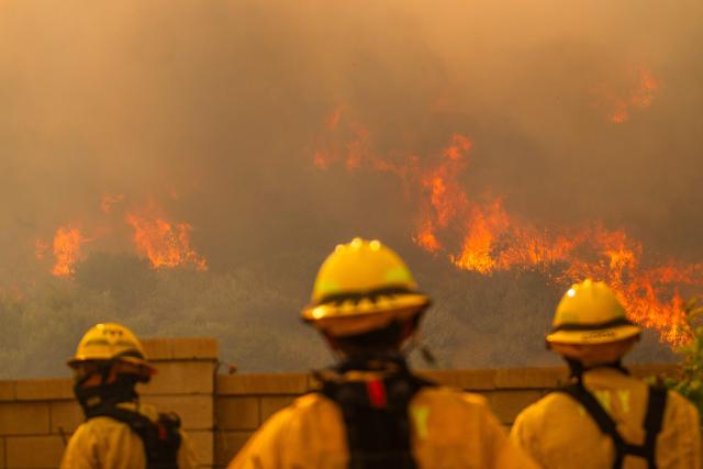 Fire fighters monitor the Sandy Fire as it burns in the hills close to a residential area in Simi Valley, California, on May 18, 2026. About 24,000 people in Simi Valley, 40 miles northwest of Los Angeles, are under mandatory evacuation orders as the Sandy Fire is "spreading dangerously fast" according to fire officials. (Photo by Apu GOMES / AFP)
