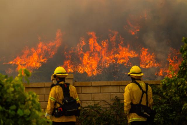 Fire fighters monitor the Sandy Fire as it burns in the hills close to a residential area in Simi Valley, California, on May 18, 2026. About 24,000 people in Simi Valley, 40 miles northwest of Los Angeles, are under mandatory evacuation orders as the Sandy Fire is "spreading dangerously fast" according to fire officials. (Photo by Apu GOMES / AFP)