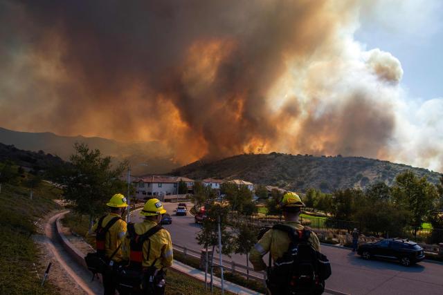 Fire fighters monitor the Sandy Fire as it burns in the hills close to a residential area in Simi Valley, California, on May 18, 2026. About 24,000 people in Simi Valley, 40 miles northwest of Los Angeles, are under mandatory evacuation orders as the Sandy Fire is "spreading dangerously fast" according to fire officials. (Photo by Apu GOMES / AFP)