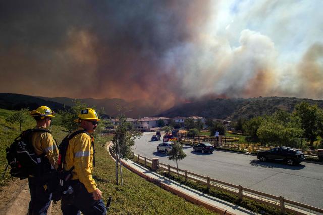 Fire fighters monitor the Sandy Fire as it burns in the hills close to a residential area in Simi Valley, California, on May 18, 2026. About 24,000 people in Simi Valley, 40 miles northwest of Los Angeles, are under mandatory evacuation orders as the Sandy Fire is "spreading dangerously fast" according to fire officials. (Photo by Apu GOMES / AFP)