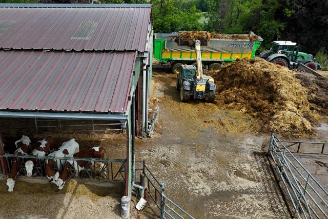This aerial photo shows manure being loaded onto a trailer for transport to a biomethane plant, at a farm in Blajan, south-western France on May 18, 2026. The Blajan plant processes some 27,000 tonnes of biomass each year, and 20 MWh of biomethane are injected into the French natural gas providor (GRDF) network, equivalent to the consumption of a town of 12,000 inhabitants. (Photo by Ed JONES / AFP)