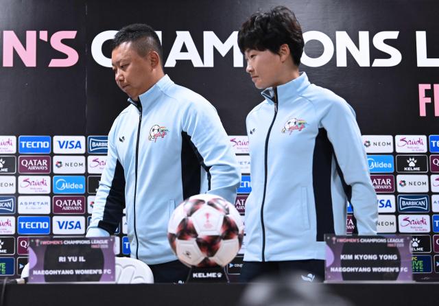 North Korea's Naegohyang Women's FC head coach Ri Yu Il (L) and his player Kim Kyong Yong (R) leave after a press conference at Suwon Sports Complex in Suwon on May 19, 2026, ahead of the Women's Asian Champions League semi-final football match against South Korea's Suwon FC Women. (Photo by JUNG YEON-JE / POOL / AFP)