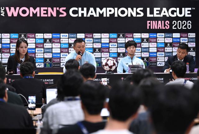 North Korea's Naegohyang Women's FC head coach Ri Yu Il (centre L) and his player Kim Kyong Yong (centre R) attend a press conference at Suwon Sports Complex in Suwon on May 19, 2026, ahead of the Women's Asian Champions League semi-final football match against South Korea's Suwon FC Women. (Photo by JUNG YEON-JE / POOL / AFP)