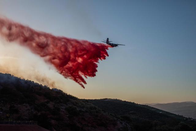 CORRECTION / A Cal Fire aircraft drops fire retardant on the Sandy Fire as it burns in the hills near a residential area in Simi Valley, California on May 18, 2026. A brush fire broke out May 15 in the suburbs of Los Angeles, spreading rapidly and prompting authorities to issue evacuation orders for thousands of residents. Dubbed the Sandy Fire, the blaze broke out late morning in Simi Valley, a city of roughly 125,000 residents about 40 miles (60 kilometers) northwest of downtown Los Angeles. (Photo by Apu GOMES / AFP) / The erroneous mention[s] appearing in the metadata of this photo by Apu GOMES has been modified in AFP systems in the following manner: [May 18] instead of [May 15]. Please immediately remove the erroneous mention[s] from all your online services and delete it (them) from your servers. If you have been authorized by AFP to distribute it (them) to third parties, please ensure that the same actions are carried out by them. Failure to promptly comply with these instructions will entail liability on your part for any continued or post notification usage. Therefore we thank you very much for all your attention and prompt action. We are sorry for the inconvenience this notification may cause and remain at your disposal for any further information you may require.