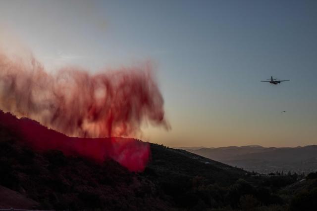 CORRECTION / Fire retardant dropped by a Cal Fire aircraft falls on the Sandy Fire as it burns in the hills near a residential area in Simi Valley, California on May 18, 2026. A brush fire broke out May 15 in the suburbs of Los Angeles, spreading rapidly and prompting authorities to issue evacuation orders for thousands of residents. Dubbed the Sandy Fire, the blaze broke out late morning in Simi Valley, a city of roughly 125,000 residents about 40 miles (60 kilometers) northwest of downtown Los Angeles. (Photo by Apu GOMES / AFP) / The erroneous mention[s] appearing in the metadata of this photo by Apu GOMES has been modified in AFP systems in the following manner: [May 18] instead of [May 15]. Please immediately remove the erroneous mention[s] from all your online services and delete it (them) from your servers. If you have been authorized by AFP to distribute it (them) to third parties, please ensure that the same actions are carried out by them. Failure to promptly comply with these instructions will entail liability on your part for any continued or post notification usage. Therefore we thank you very much for all your attention and prompt action. We are sorry for the inconvenience this notification may cause and remain at your disposal for any further information you may require.