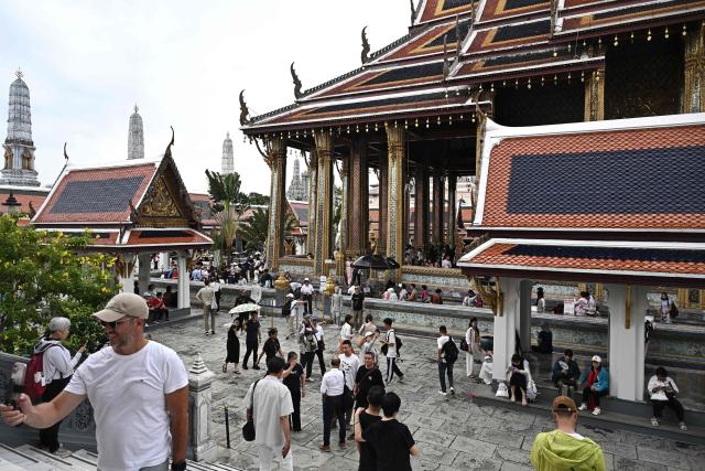 Visitors walk around the Grand Palace in Bangkok on May 20, 2026. Thailand is drastically cutting the length of visa-free stays for tourists from more than 90 countries in an effort to curb crime involving foreign nationals. (Photo by Lillian SUWANRUMPHA / AFP)
