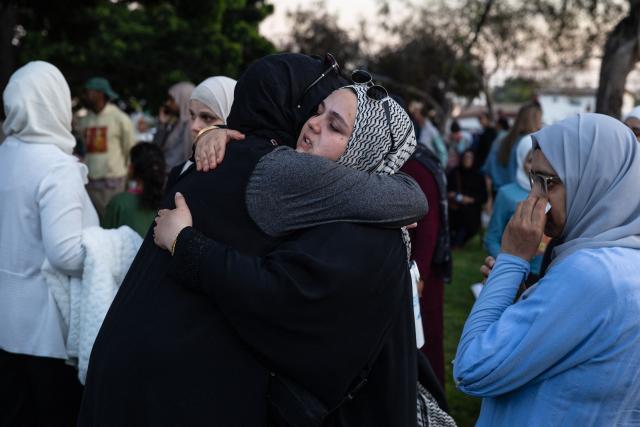 Community members embrace during a vigil for victims and families of a shooting at the Islamic Center of San Diego in San Diego, California, on May 19, 2026, a day after the attack. A shooting at a mosque complex in California on May 18, 2026 killed three people, with two suspected teenage gunmen later found dead in a car from self-inflicted gunshot wounds, police said. (Photo by Zoë Meyers / AFP)
