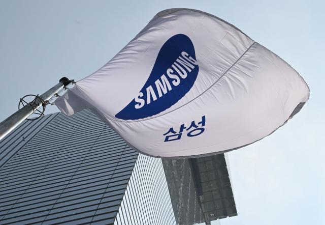 (FILES) A Samsung flag flutters outside the company's Seocho building in Seoul on July 8, 2025. The labour union at South Korean chip giant Samsung Electronics said on May 20, 2026 it would launch a planned strike after talks over bonus payouts collapsed. (Photo by Jung Yeon-je / AFP)