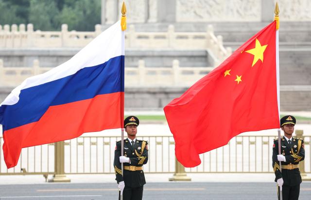 In this pool photograph distributed by the Russian state agency Sputnik, Russian and Chinese national flags are displayed during a welcome ceremony for Russia's President Vladimir Putin at the Great Hall of the People in Beijing on May 20, 2026. (Photo by Alexander KAZAKOV / POOL / AFP)