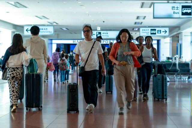 Travellers make their way in the arrivals terminal at Haneda Airport in Tokyo on May 20, 2026. (Photo by Kazuhiro NOGI / AFP)