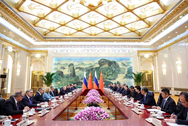 In this pool photograph distributed by the Russian state agency Sputnik, Russia's President Vladimir Putin (centre L) and China's President Xi Jinping (centre R) take part in a meeting in Beijing on May 20, 2026. (Photo by Alexander KAZAKOV / POOL / AFP)
