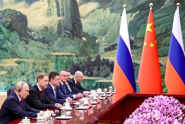 In this pool photograph distributed by the Russian state agency Sputnik, Russia's President Vladimir Putin (L) taking part in a meeting with China's President Xi Jinping in Beijing on May 20, 2026. (Photo by Alexander KAZAKOV / POOL / AFP)