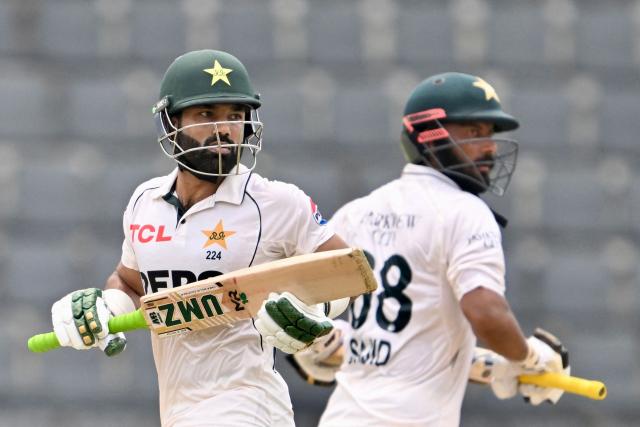 Pakistan’s Muhammad Rizwan (L) and Sajid Khan (R) run between the wickets during the fifth day of the second Test cricket match between Bangladesh and Pakistan at the Sylhet International Cricket Stadium in Sylhet on May 20, 2026. (Photo by MUNIR UZ ZAMAN / AFP)