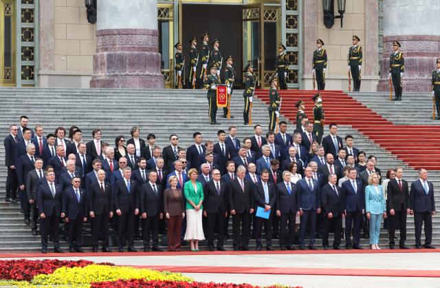 In this pool photograph distributed by the Russian state agency Sputnik, the Russian delegation stands on the steps of the Great Hall of the People during a welcome ceremony for Russia's President Vladimir Putin (not pictured) in Beijing on May 20, 2026. (Photo by Alexander KAZAKOV / POOL / AFP)