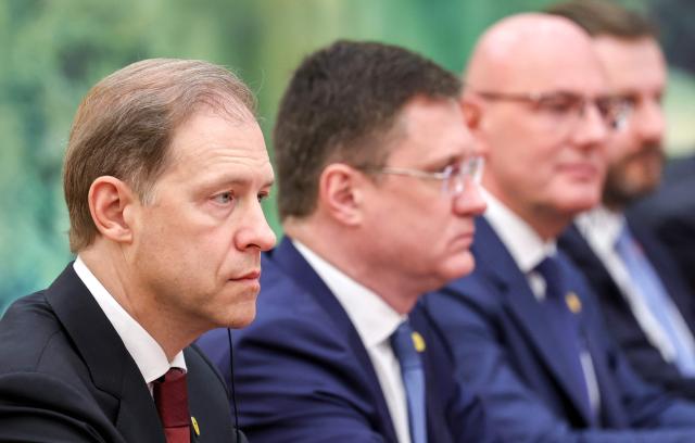 In this pool photograph distributed by the Russian state agency Sputnik, Russia's First Deputy Prime Minister Denis Manturov (L) attends a meeting with Russian President Vladimir Putin (not pictured) and China's President Xi Jinping (not pictured) in Beijing on May 20, 2026. (Photo by Alexander KAZAKOV / POOL / AFP)