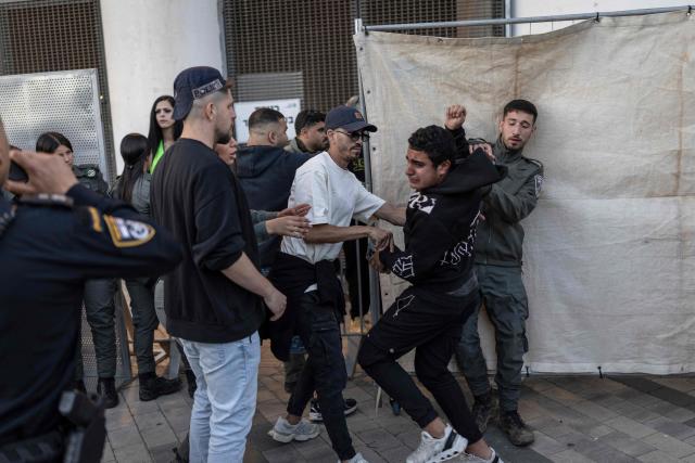 A policeman stops a Beitar Jerusalem fan attempting to breach the stadium without a ticket ahead of a match against Hapoel Tel Aviv at Bloomfield Stadium in Tel Aviv on May 6, 2026. (Photo by Ilia YEFIMOVICH / AFP)
