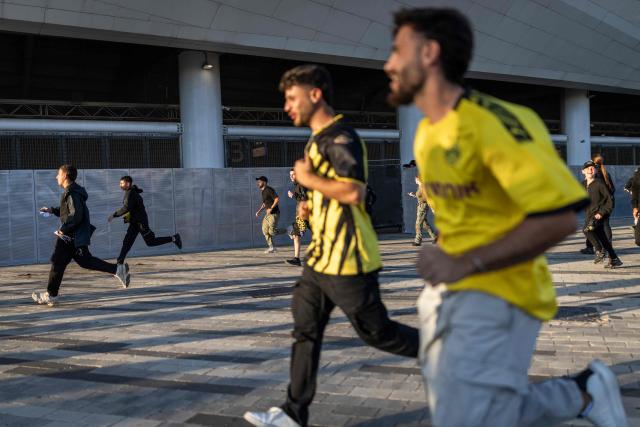 Beitar Jerusalem fans run from police as they attempt to enter the stadium without tickets ahead of a match against Hapoel Tel Aviv at Bloomfield Stadium in Tel Aviv on May 6, 2026. (Photo by Ilia YEFIMOVICH / AFP)