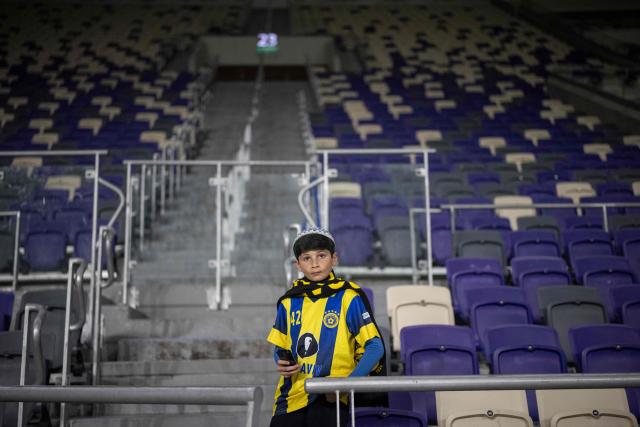 A Maccabi Tel Aviv supporter stands alone in an empty section as the team plays against Maccabi Jaffa in the Israel State Cup at Bloomfield Stadium in Tel Aviv on February 6, 2026. (Photo by Ilia YEFIMOVICH / AFP)