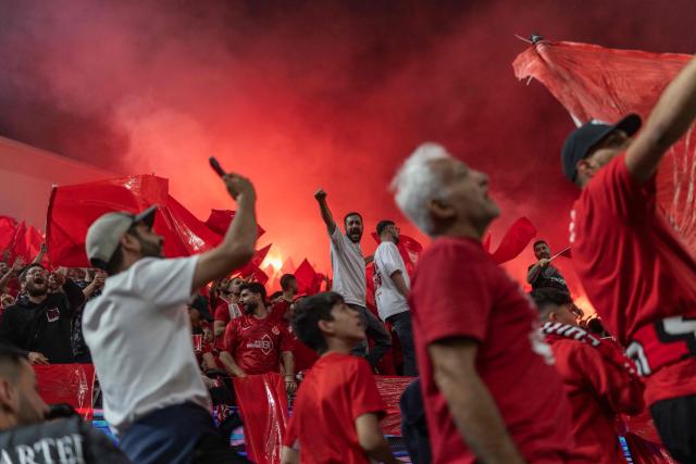 Hapoel Tel Aviv fans light pyrotechnics during the last derby match of the season against Maccabi Tel Aviv at Bloomfield Stadium in Tel Aviv on May 6, 2026. (Photo by Ilia YEFIMOVICH / AFP)