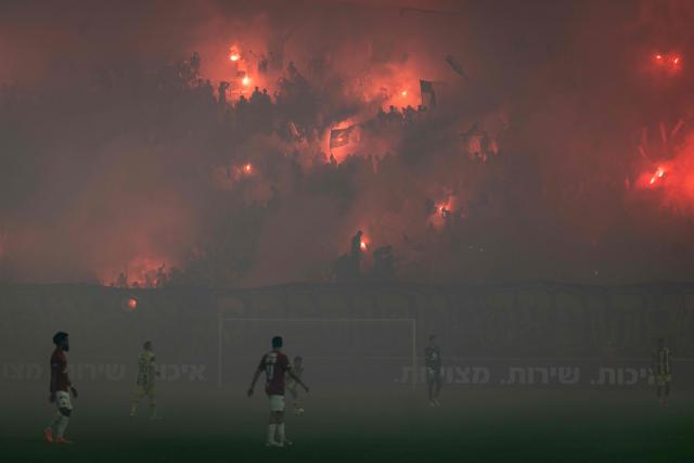 TOPSHOT - Maccabi Tel Aviv fans light pyrotechnics during the last derby match of the season against Hapoel Tel Aviv at Bloomfield Stadium in Tel Aviv on May 6, 2026. (Photo by Ilia YEFIMOVICH / AFP)