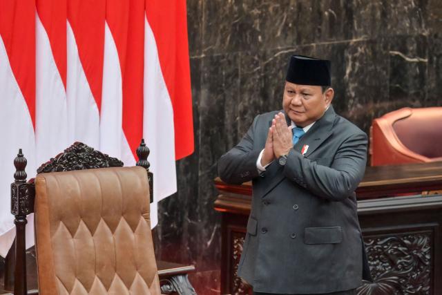 Indonesian President Prabowo Subianto (L) greets lawmakers before delivering a speech on the macroeconomic framework at the Parliament building in Jakarta on May 20, 2026. (Photo by BAY ISMOYO / AFP)