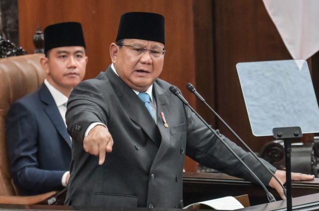 Indonesian President Prabowo Subianto (R) delivers a speech on the macroeconomic framework to lawmakers as Vice President Gibran Rakabuming Raka (L) looks on at the Parliament building in Jakarta on May 20, 2026. (Photo by BAY ISMOYO / AFP)
