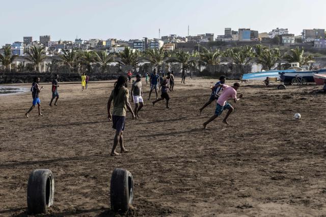 People play football at Gamboa Beach in Praia, on May 19, 2026. (Photo by PATRICK MEINHARDT / AFP)