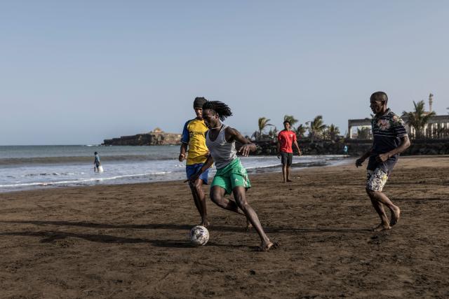 People play football at Gamboa Beach in Praia, on May 19, 2026. (Photo by PATRICK MEINHARDT / AFP)