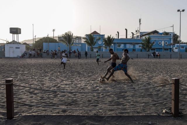 People play football at Gamboa Beach in Praia, on May 19, 2026. (Photo by PATRICK MEINHARDT / AFP)