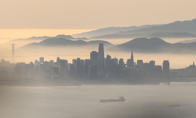 TOPSHOT - An aerial view shows the backlit skyline of San Francisco, California on May 19, 2026. (Photo by JOSH EDELSON / AFP)