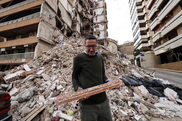 Wael Sabbagh, who lost his mother and brother when their house in Beirut’s Tallet el-Khayat, an affluent residential neighborhood was struck by an Israeli strike in April, looks at debris in front of the remains of the building on May 18, 2026. Standing in front of their parents’ building, which was destroyed by an Israeli strike in Beirut, Ghida Krisht and Wael Sabbagh make a solemn vow: to seek justice through international bodies for their slain families. On this April 8, the “Black Wednesday” when massive Israeli strikes killed more than 350 people in Lebanon according to authorities, Ghida lost her parents and a close relative, and Wael lost his mother and brother. The final strike on Beirut that day targeted the building where they had lived for some fifty years in Tallet el-Khayat, an affluent residential neighborhood where they believed they were safe. (Photo by Anwar AMRO / AFP)