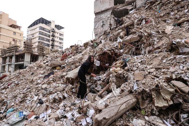 Ghida Krisht, who lost her mother and father when their house in Beirut’s Tallet el-Khayat, an affluent residential neighborhood was struck by an Israeli strike in April, stands on the rublle of the building on May 18, 2026. Standing in front of their parents’ building, which was destroyed by an Israeli strike in Beirut, Ghida Krisht and Wael Sabbagh make a solemn vow: to seek justice through international bodies for their slain families. On this April 8, the “Black Wednesday” when massive Israeli strikes killed more than 350 people in Lebanon according to authorities, Ghida lost her parents and a close relative, and Wael lost his mother and brother. The final strike on Beirut that day targeted the building where they had lived for some fifty years in Tallet el-Khayat, an affluent residential neighborhood where they believed they were safe. (Photo by Anwar AMRO / AFP)