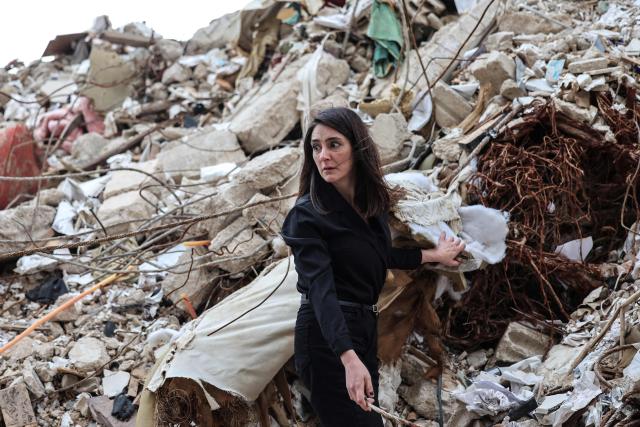 Ghida Krisht, who lost her mother and father when their house in Beirut’s Tallet el-Khayat, an affluent residential neighborhood was struck by an Israeli strike in April, stands on the rublle of the building on May 18, 2026. Standing in front of their parents’ building, which was destroyed by an Israeli strike in Beirut, Ghida Krisht and Wael Sabbagh make a solemn vow: to seek justice through international bodies for their slain families. On this April 8, the “Black Wednesday” when massive Israeli strikes killed more than 350 people in Lebanon according to authorities, Ghida lost her parents and a close relative, and Wael lost his mother and brother. The final strike on Beirut that day targeted the building where they had lived for some fifty years in Tallet el-Khayat, an affluent residential neighborhood where they believed they were safe. (Photo by Anwar AMRO / AFP)