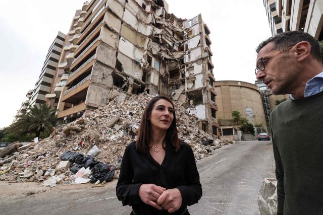 Ghida Krisht (L) and Wael Sabbagh, who both lost relatives when their apartments in Beirut’s Tallet el-Khayat, an affluent residential neighborhood were struck by an Israeli strike in April, stand in front of the destroyed building on May 18, 2026.”. Standing in front of their parents’ building, which was destroyed by an Israeli strike in Beirut, Ghida Krisht and Wael Sabbagh make a solemn vow: to seek justice through international bodies for their slain families. On this April 8, the “Black Wednesday” when massive Israeli strikes killed more than 350 people in Lebanon according to authorities, Ghida lost her parents and a close relative, and Wael lost his mother and brother. The final strike on Beirut that day targeted the building where they had lived for some fifty years in Tallet el-Khayat, an affluent residential neighborhood where they believed they were safe. (Photo by Anwar AMRO / AFP)