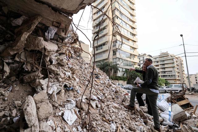 Ghida Krisht and Wael Sabbagh inspect the rubble of a building destroyed by an Israeli strike in Beirut’s Tallet el-Khayyet neighbourhood on May 18, 2026. Standing in front of their parents’ building, which was destroyed by an Israeli strike in Beirut, Ghida Krisht and Wael Sabbagh make a solemn vow: to seek justice through international bodies for their slain families. On this April 8, the “Black Wednesday” when massive Israeli strikes killed more than 350 people in Lebanon according to authorities, Ghida lost her parents and a close relative, and Wael lost his mother and brother. The final strike on Beirut that day targeted the building where they had lived for some fifty years in Tallet el-Khayat, an affluent residential neighborhood where they believed they were safe. (Photo by Anwar AMRO / AFP)