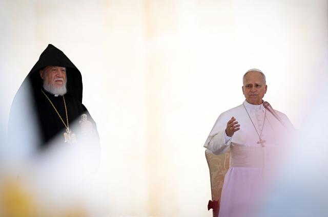 Pope Leo XIV (R) addresses the crowd next to Supreme Patriarch and Catholicos of All Armenians Garegin II (Karekin II), head of the Armenian Apostolic Church, during the weekly general audience at St Peter's Square in the Vatican, on May 20, 2026. (Photo by TIZIANA FABI / AFP)